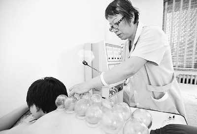 副主任医师尹淑华在给患者拔罐